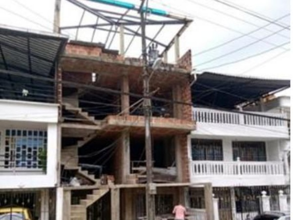 En Buenaventura, un hombre construye un edificio de 4 pisos y tiene que mover un poste eléctrico