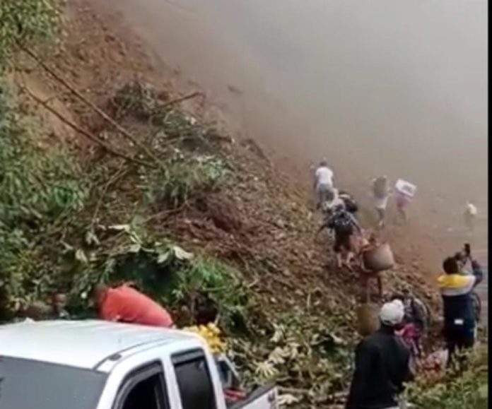 A pesar del riesgo, la gente pasando por el derrumbe en San José del Palmar en Chocó